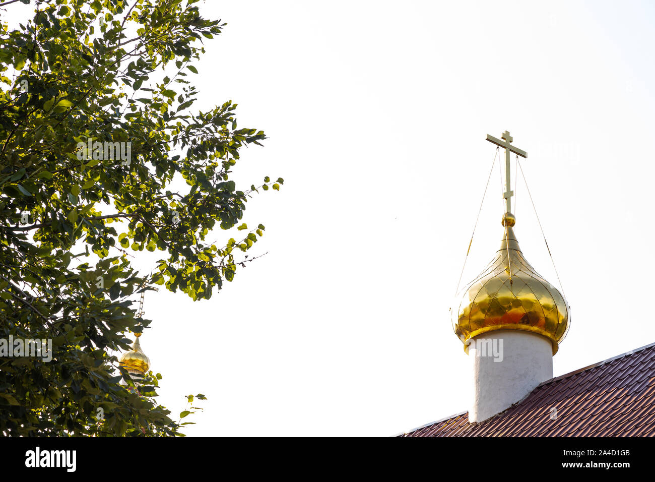 Ansicht Von Unten Auf Das Glanzende Christliche Kirche Dome Mit Kreuz Auf Rotem Dach Gegen Baum Und Weissen Himmel Stockfotografie Alamy