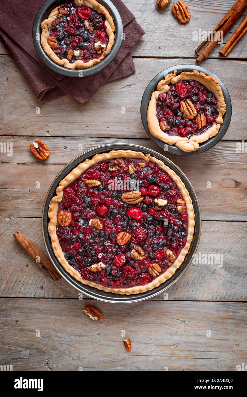 Herbst Preiselbeeren und Pecan Kuchen oder Torten auf hölzernen Hintergrund, Ansicht von oben. Hausgemachte saisonale Gebäck für Thanksgiving und Herbstferien. Stockfoto