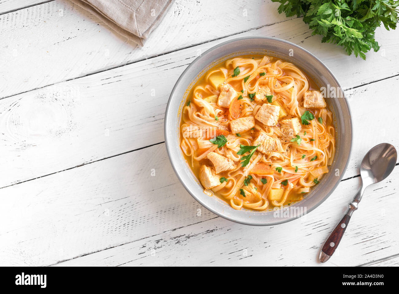 Huhn Nudelsuppe mit Gemüse und Petersilie auf weißen, Ansicht von oben, kopieren. Hausgemachte Huhn oder Truthahn Suppe. Stockfoto