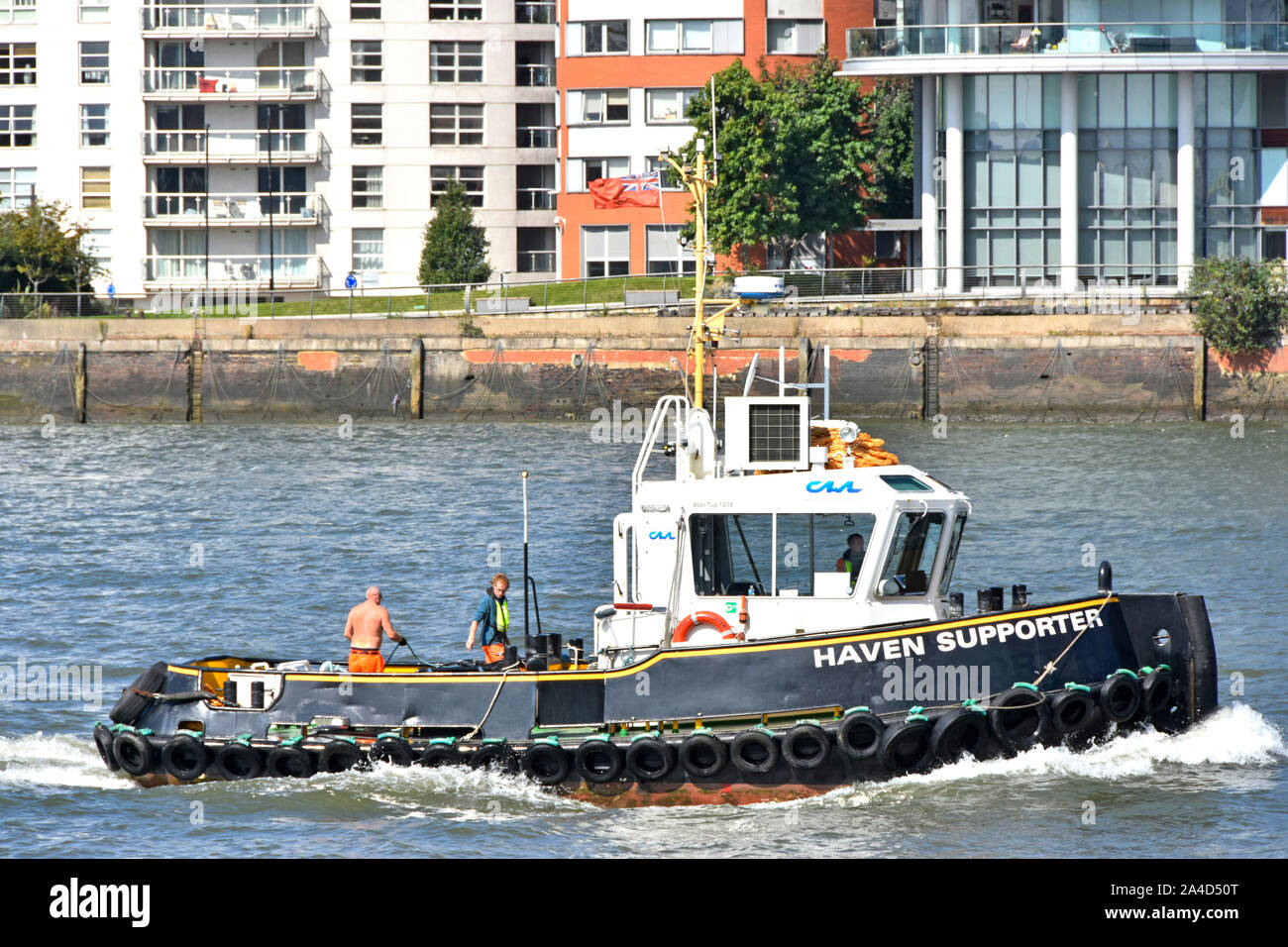 Close up Seitenansicht von Haven Unterstützer tug & Push bug Boot mit zwei Besatzungsmitglieder Arbeiten an Deck tugboat unter weg Themse East London England Großbritannien Stockfoto