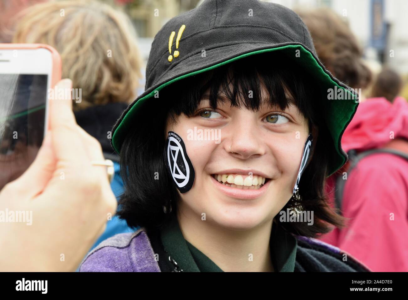 Demonstrant mit ER Aufkleber, Aussterben Rebellion Protest, Tag 6, Trafalgar Square, London. Großbritannien Stockfoto
