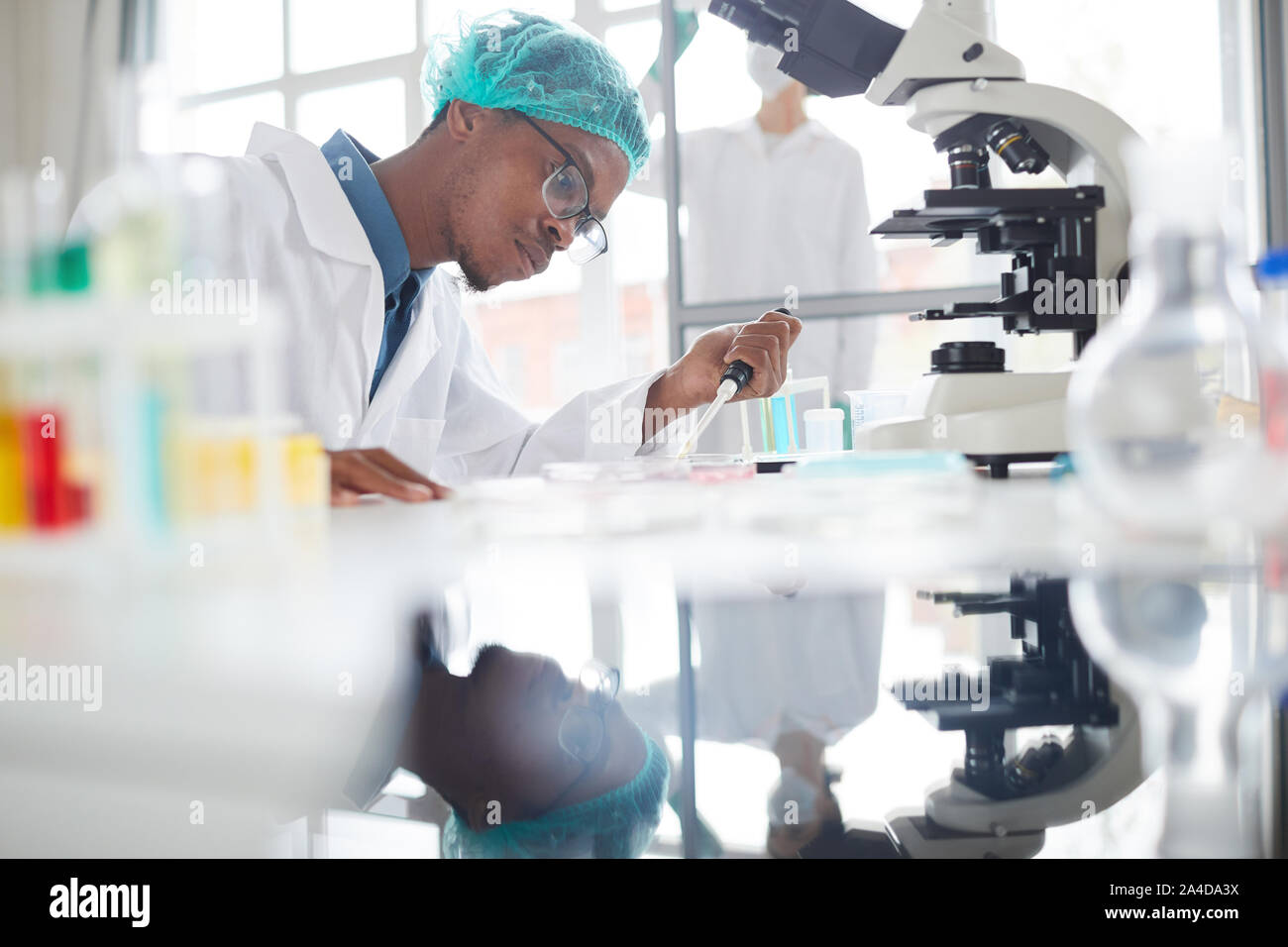 Seitenansicht Portrait von Afro-amerikanische Mann im Labor Vorbereitung der Proben in der Petrischale für medizinische Forschung arbeiten, kopieren Raum Stockfoto