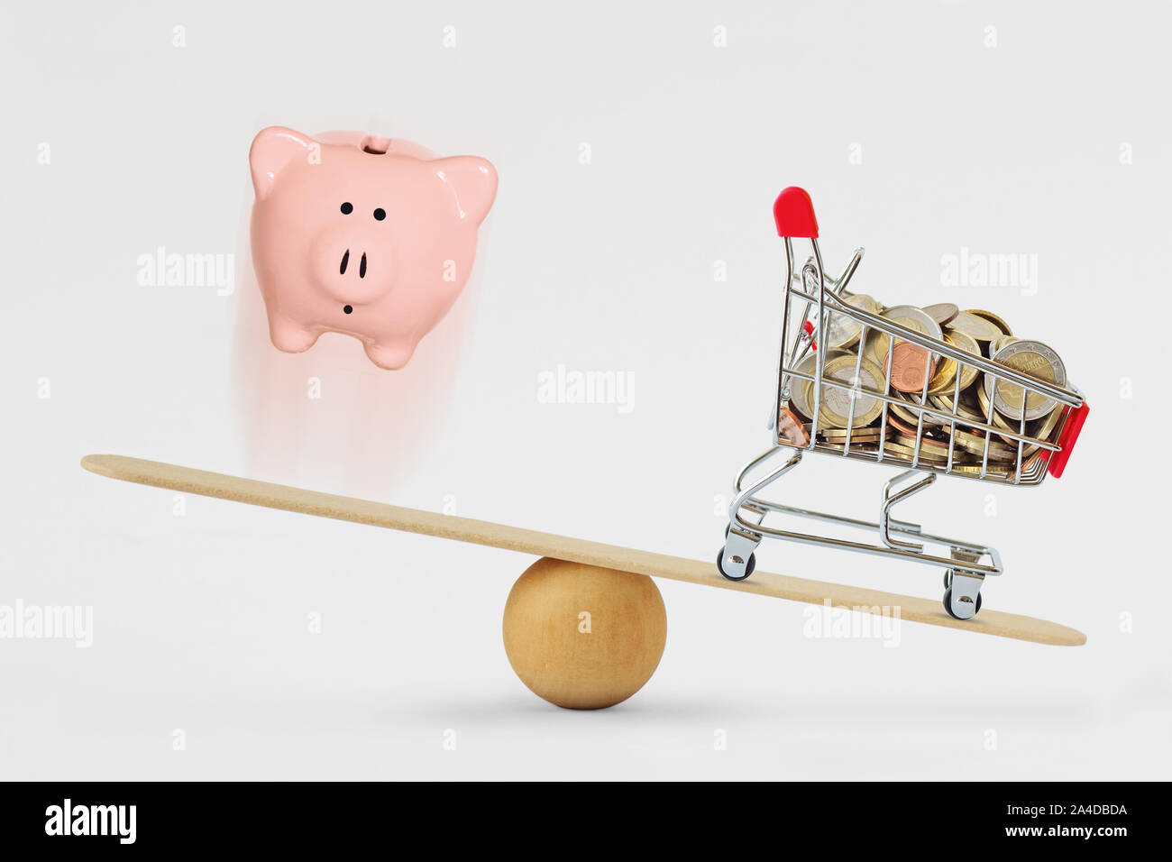 Piggy Bank und Warenkorb mit Münzen auf Balance Scale-Konzept der zunehmenden Käufe Stockfoto