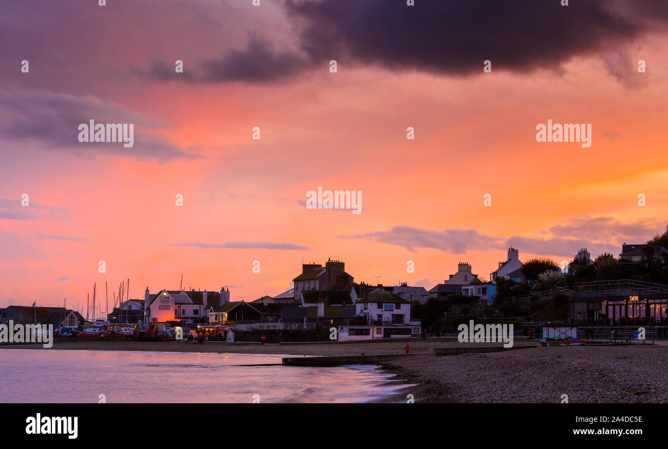 Lyme Regis, Dorset, Großbritannien. 13. Oktober 2019. UK Wetter: der Himmel über dem Cobb Harbout in Lyme Regis glüht mit herrlichen Rosa- und Rottöne bei Sonnenuntergang nach einem trüben und regnerischen Tag. Credit: Celia McMahon/Alamy Leben Nachrichten. Stockfoto