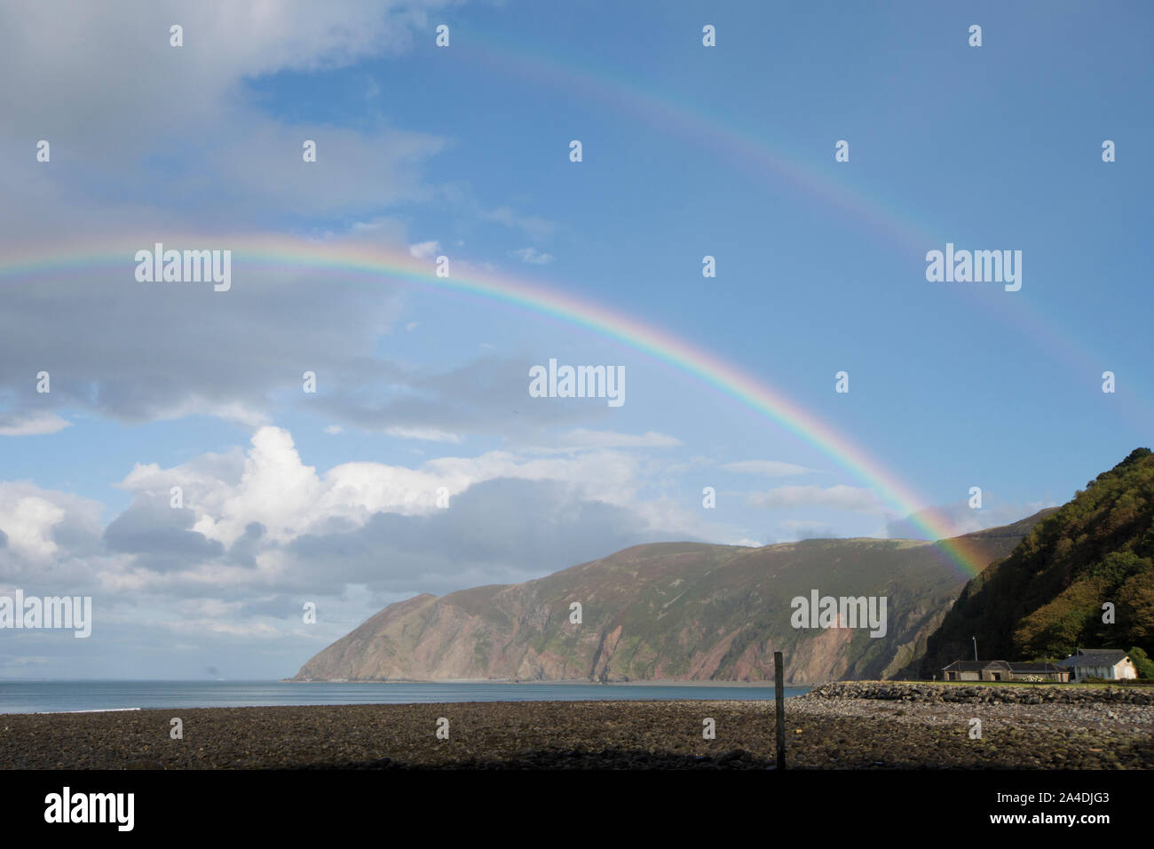 Regenbogen über dem Meer und die Bucht von Lynmouth, Devon, Blick auf das Vorland, blauer Himmel Regenbogen, Großbritannien Stockfoto