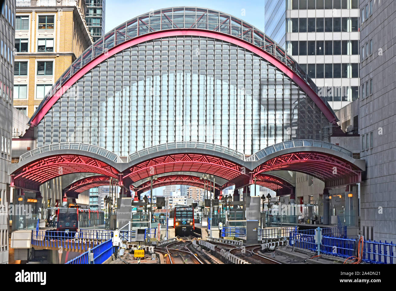 Hohe gewölbte Glasdach über Docklands Light Railway DLR Canary Wharf Bahnsteig Züge bei umsteigeplattformen East London England Großbritannien Stockfoto