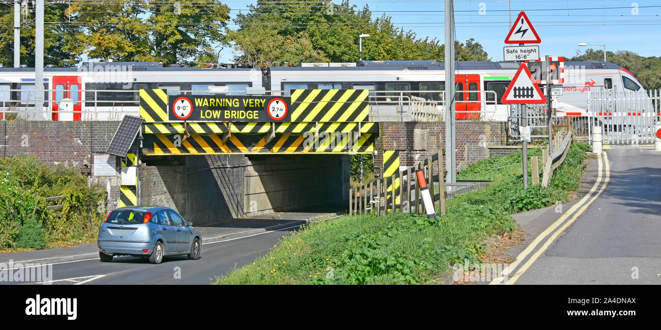 Mehr Anglia Personenzug fährt Ely Bahnhof Kreuzung low road bridge Warnmarkierungen Symbole & Warnschild Cambridgeshire England Großbritannien Stockfoto