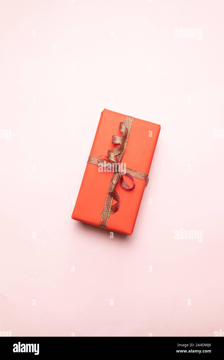 Kreative Zusammensetzung der Geschenkkarton mit gold Dekoration Bug auf rosa Hintergrund. Minimalen Begriff für Geburtstag, Muttertag oder Hochzeit. Stockfoto