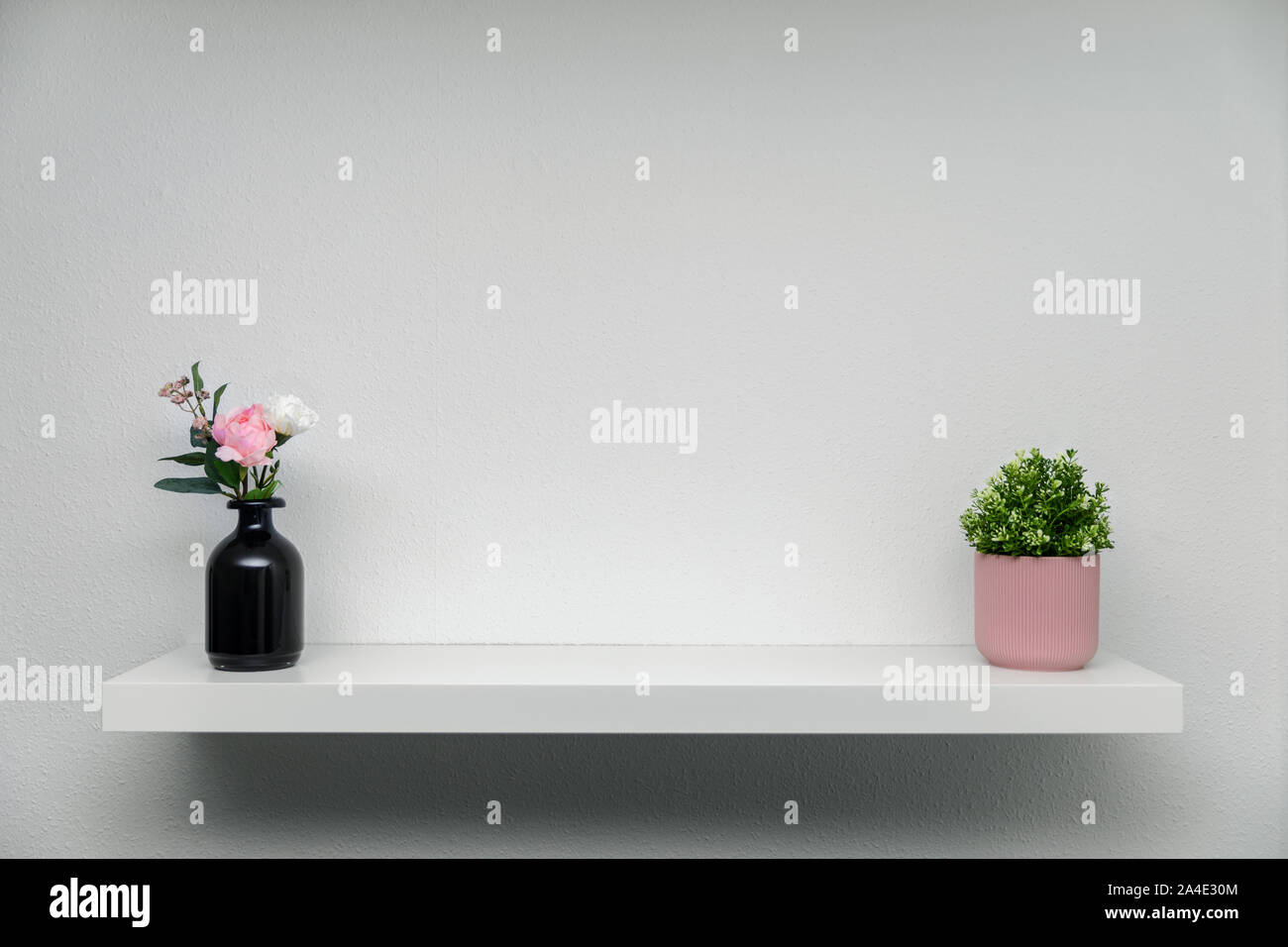 Holzregal auf weiße Wand mit grünen Pflanzen Blumenvase Stockfoto