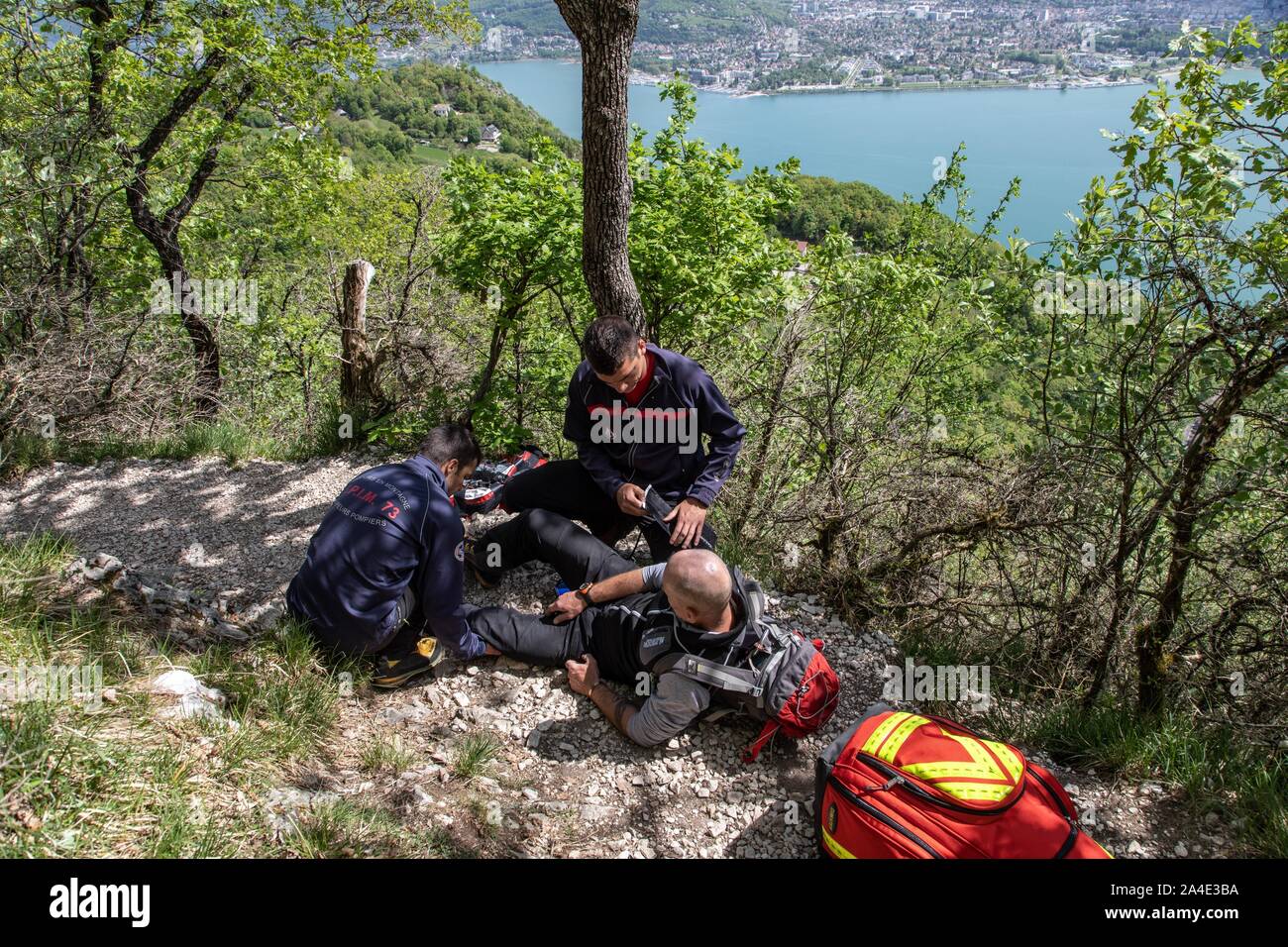 INTERVENTION DURCH DIE ERSTHELFER DER BERGRETTUNG FÜR EINEN FALL MIT EINEM verstauchten Knöchel auf den WANDERWEG IM CORNILLON WALD OBERHALB DER SEE VON LE BOURGET, LA CHAPELLE DU MONT-DU-CHAT (73), Frankreich Stockfoto