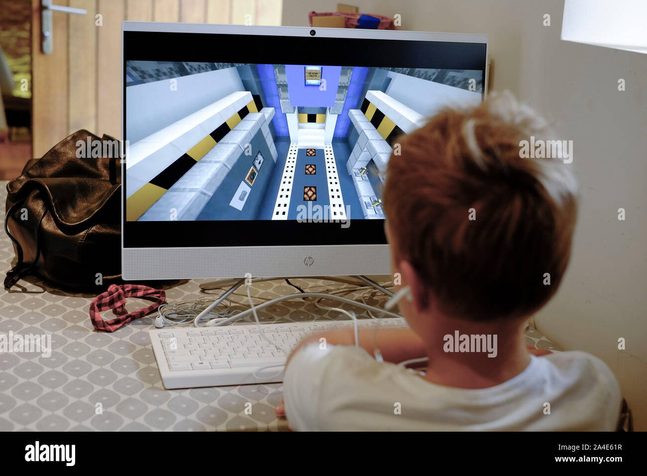 Ein kleiner Junge in Spielen der Computer video game Minecraft auf einem Computer gefesselt. Stockfoto