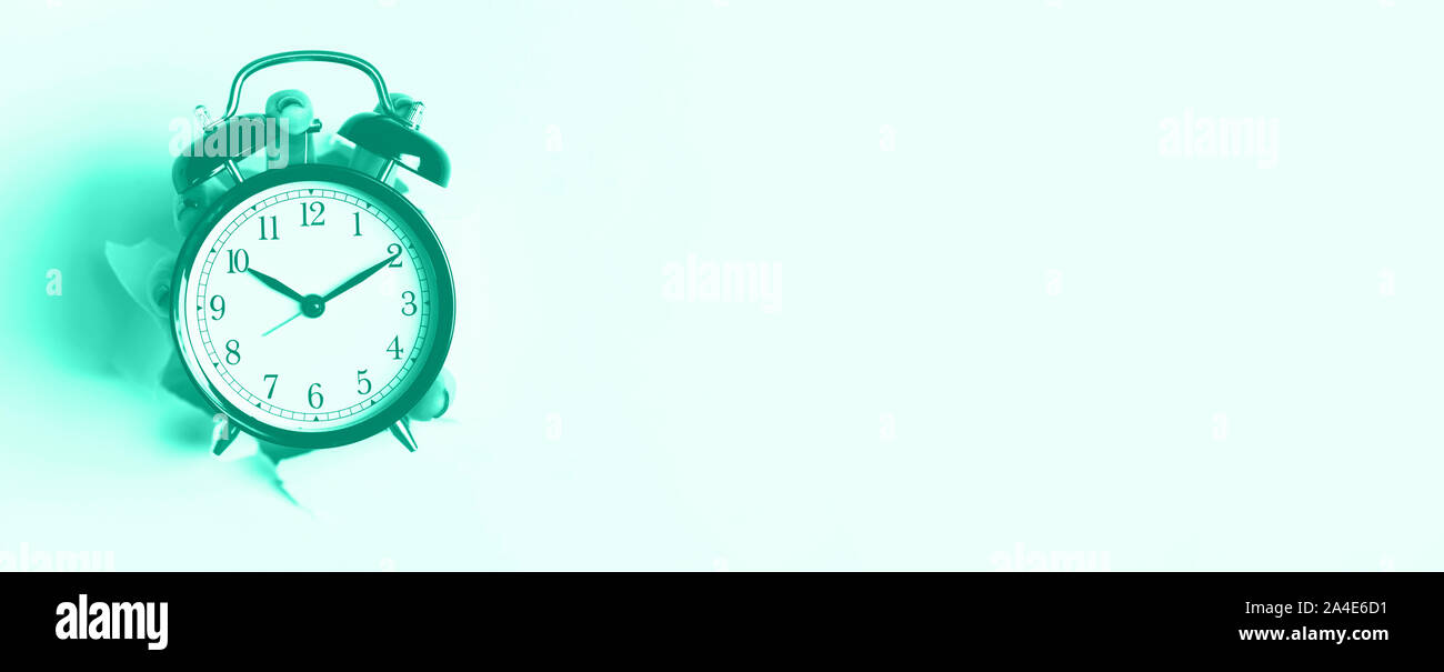 Hand, schwarz Wecker durch die Bohrung in der mint Farbe Hintergrund. Aufwachen alert Konzept. Trendy Grün und Türkis. Morgendliche Routine. Banner Stockfoto