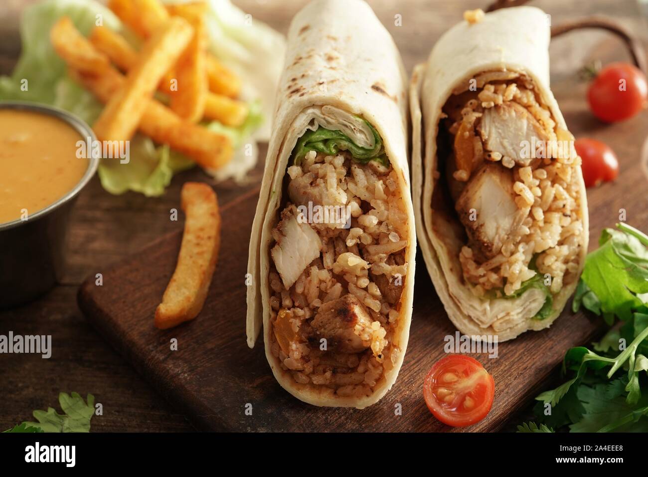 Burritos Wrap mit gegrilltem Hähnchen Reis und Gemüse auf hölzernen Hintergrund, selektiver Fokus Stockfoto