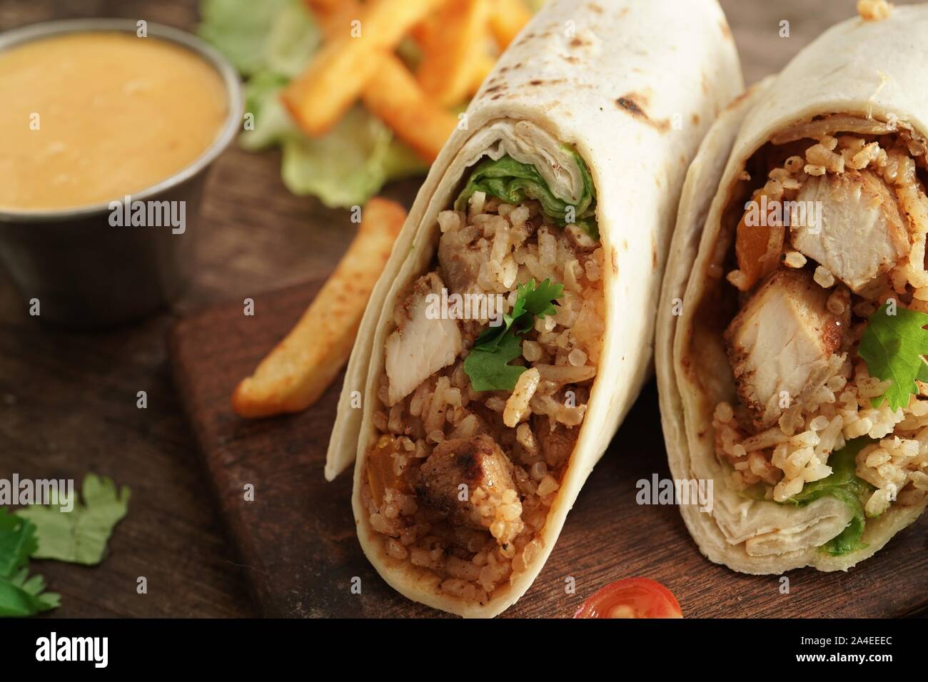 Burritos Wrap mit gegrilltem Hähnchen Reis und Gemüse auf hölzernen Hintergrund, selektiver Fokus Stockfoto