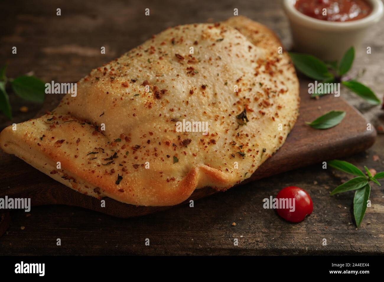 Calzone - Italienische gefaltet CheesePizza auf rustikalen hölzernen Hintergrund Stockfoto