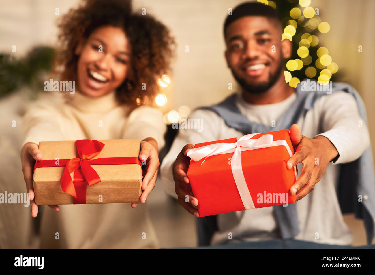 Aufgeregt afro Paar hält Weihnachten Geschenkboxen und lächelnd Stockfoto