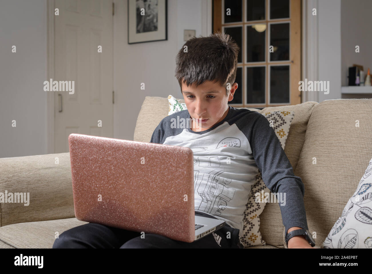 Junge, 11 Jahre alte Uhren videos auf Laptop Computer zu Hause, Großbritannien Stockfoto