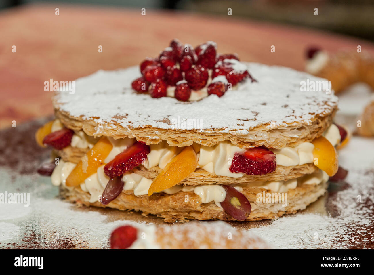 Köstliche Kuchen, Blätterteig mit frischem Obst. Pfirsich, Erdbeere, Pfirsich und Trauben. Stockfoto
