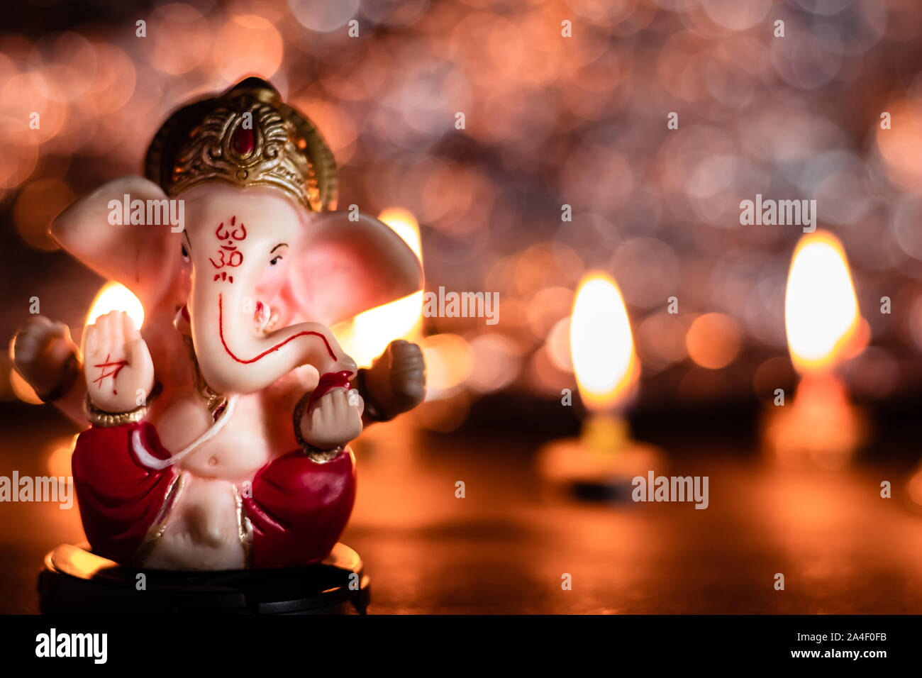 Lord Ganesha Statue in Ganesh Chaturthi-Konzept mit Kerzen im Hintergrund Stockfoto