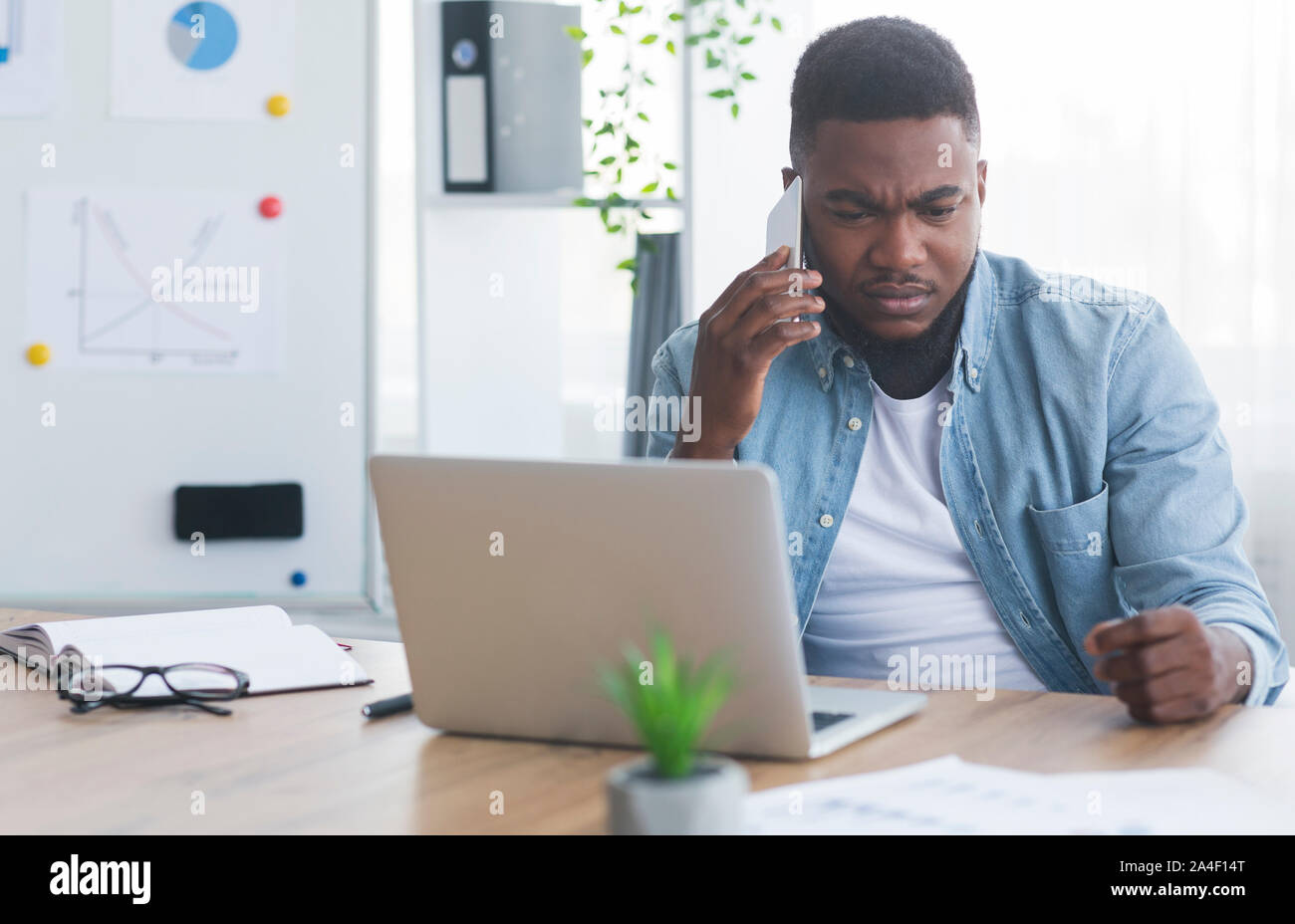 Afrikanische amerikanische Geschäftsmann empfängt fehlerhafte Nachrichten auf dem Telefon gedrückt Stockfoto