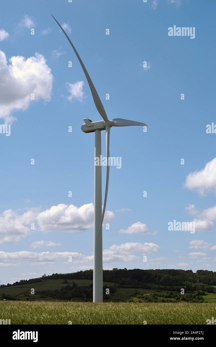 Windenergieanlagen in einer ländlichen Landschaft auf dem Hintergrund des blauen Himmels Stockfoto