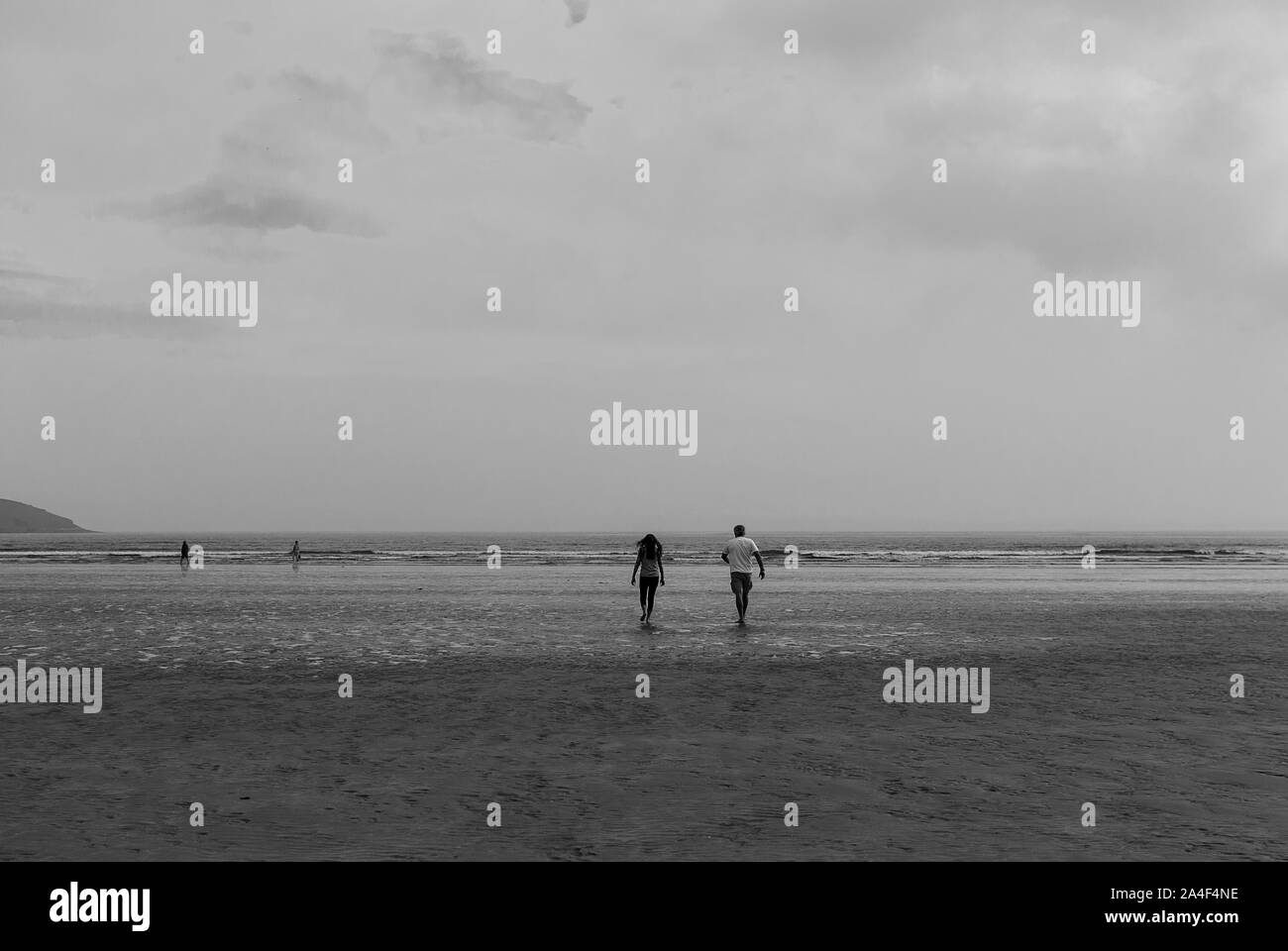 Paar am Strand hinterlassen Spuren im Sand. Ein Vater und seine tochter genießen Sie den Tag. Bewölkten Tag. Stockfoto