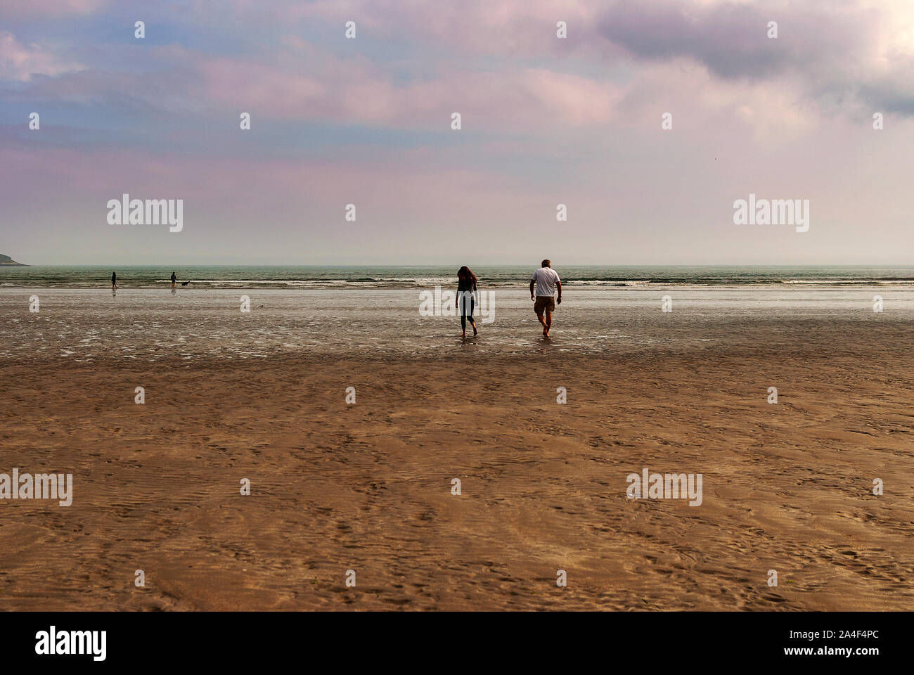 Paar am Strand hinterlassen Spuren im Sand. Ein Vater und seine tochter genießen Sie den Tag. Bewölkten Tag. Stockfoto