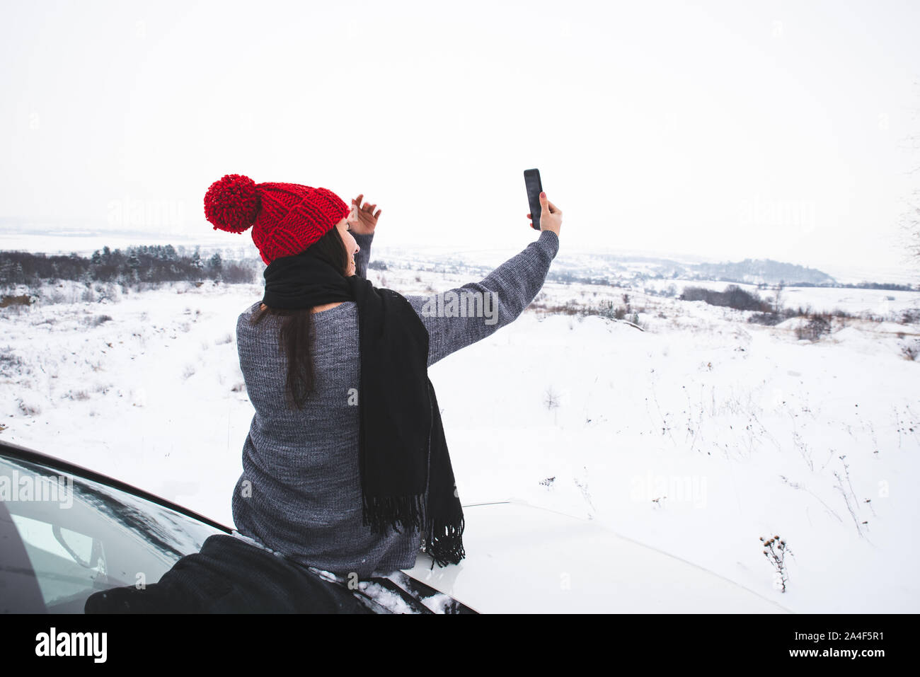 Woman sitting on car hood -Fotos und -Bildmaterial in hoher