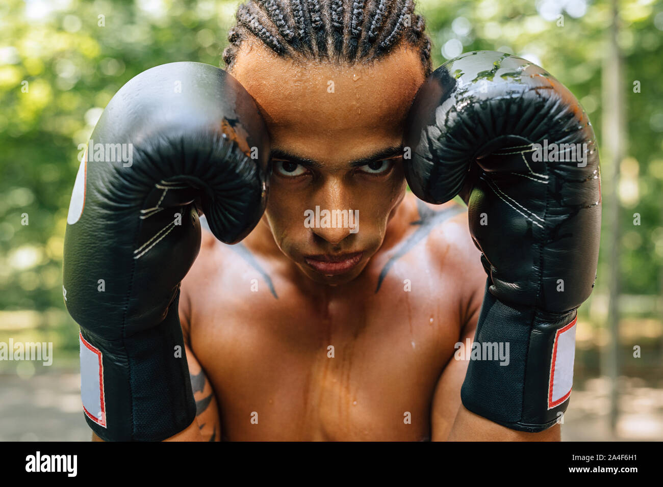 Nahaufnahme, Porträt einer geschwitzt Kickboxer mit Handschuhen und Mundschutz in die Kamera schaut Stockfoto