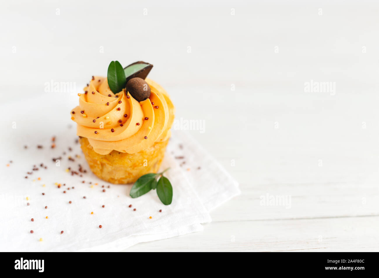 Lecker Kürbis Cupcake mit orange Creme und Dekoration auf weiße Holztisch. Für Text platzieren. Stockfoto