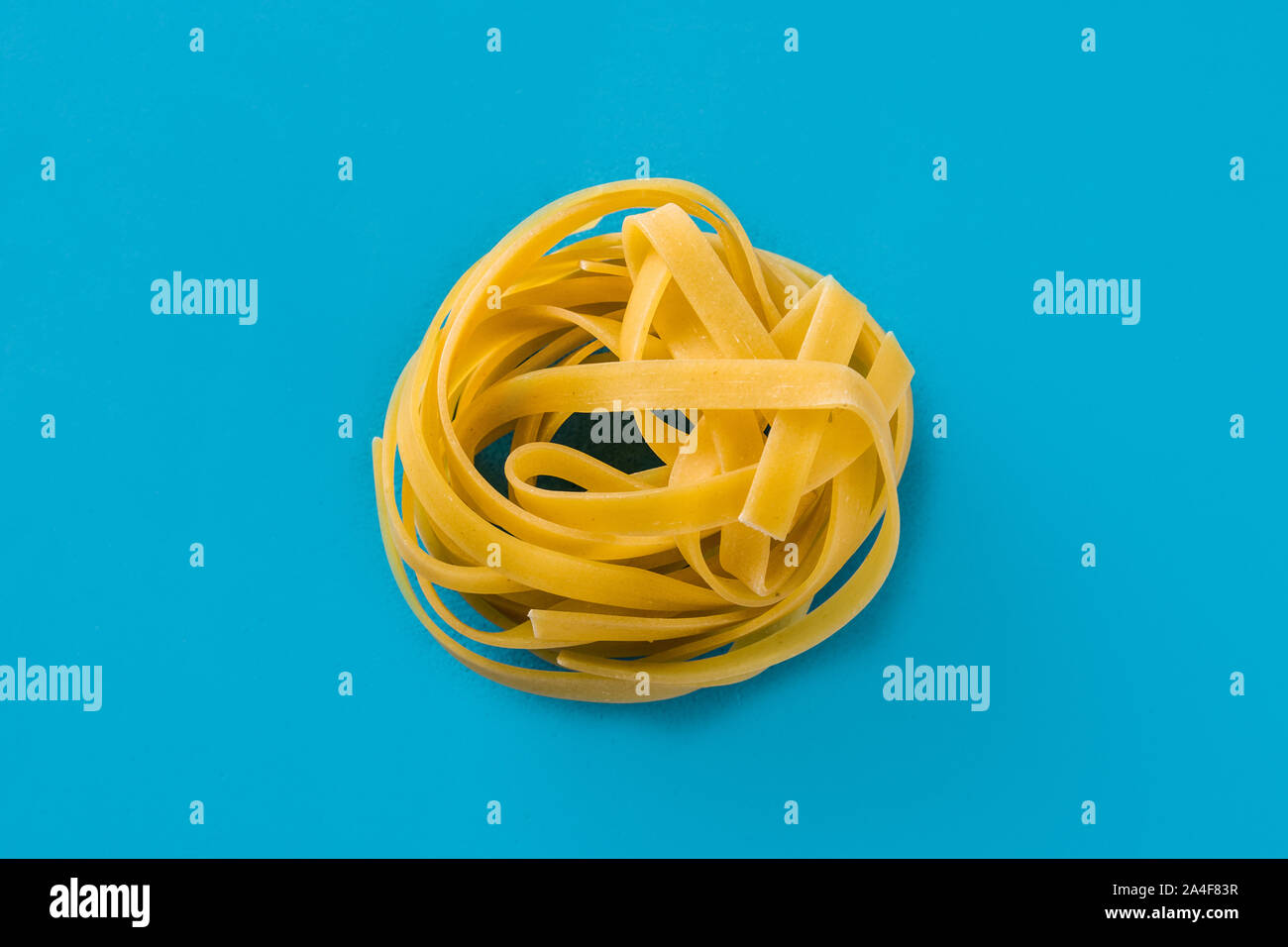 Capellini Pasta auf blauem Hintergrund Stockfoto