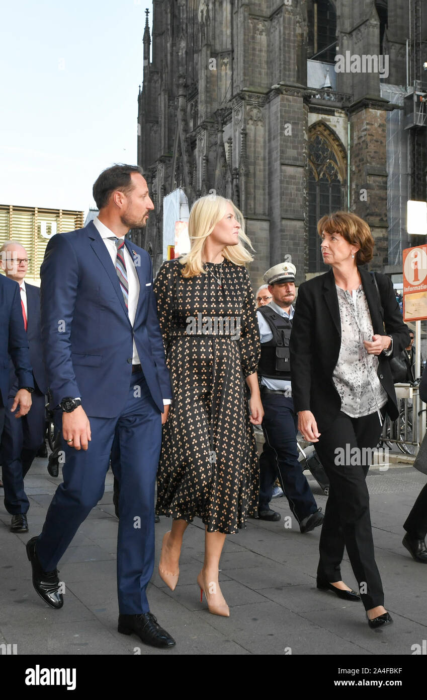 Köln, Deutschland. 14 Okt, 2019. Kronprinz Haakon von Norwegen, und Kronprinzessin Mette-Marit kommen an der Kölner Haptbahnhof von literarischen Zug und vorbei an der Kathedrale zu Ihrem Hotel. Neben ihnen läuft Henriette Rädeker, Bürgermeister von Köln. Der norwegische Kronprinz und die Kronprinzessin Reisen mit diesem Zug von Berlin über Köln nach der Frankfurter Buchmesse. Norwegen ist in diesem Jahr Ehrengast der Frankfurter Buchmesse. Foto: Jens Kalaene/dpa-Zentralbild/dpa/Alamy leben Nachrichten Stockfoto