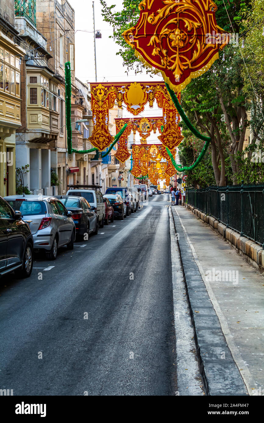 Sliema, Malta - 29. August 2019: Straße in Sliema mit roten religiösen verzierten Banner für Dorf fest (Festa) des Hl. Gregor des Großen eingerichtet. Stockfoto