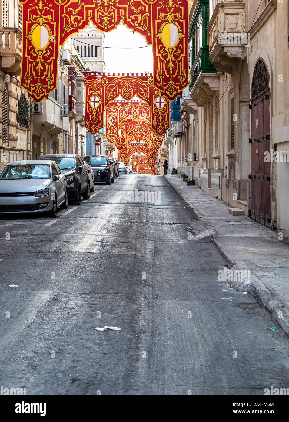 Straße in Sliema, Malta, mit roten religiösen verzierten Banner für Dorf fest (Festa) des Hl. Gregor des Großen eingerichtet. Stockfoto