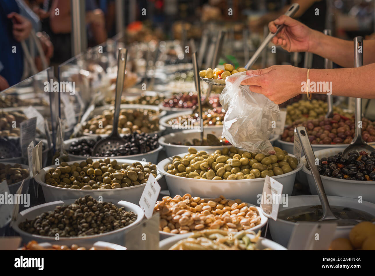 Abschaltdruck Inhaber serviert lokale Oliven im Markt der Landwirte in der Provence Abschaltdruck Stockfoto