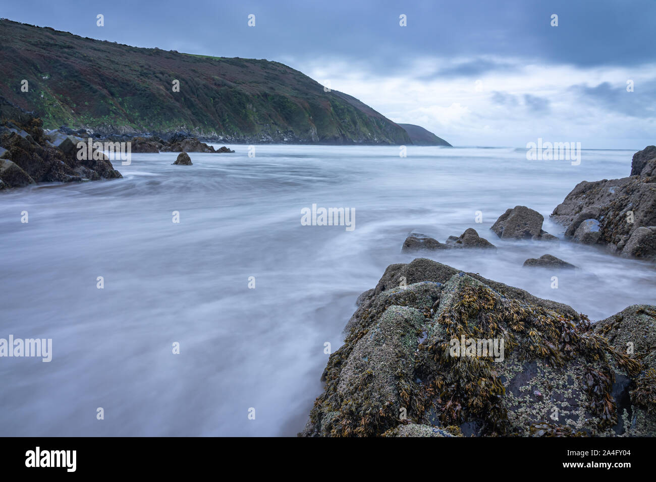 Ebbing tide fließt um Felsen ausgesetzt Stockfoto