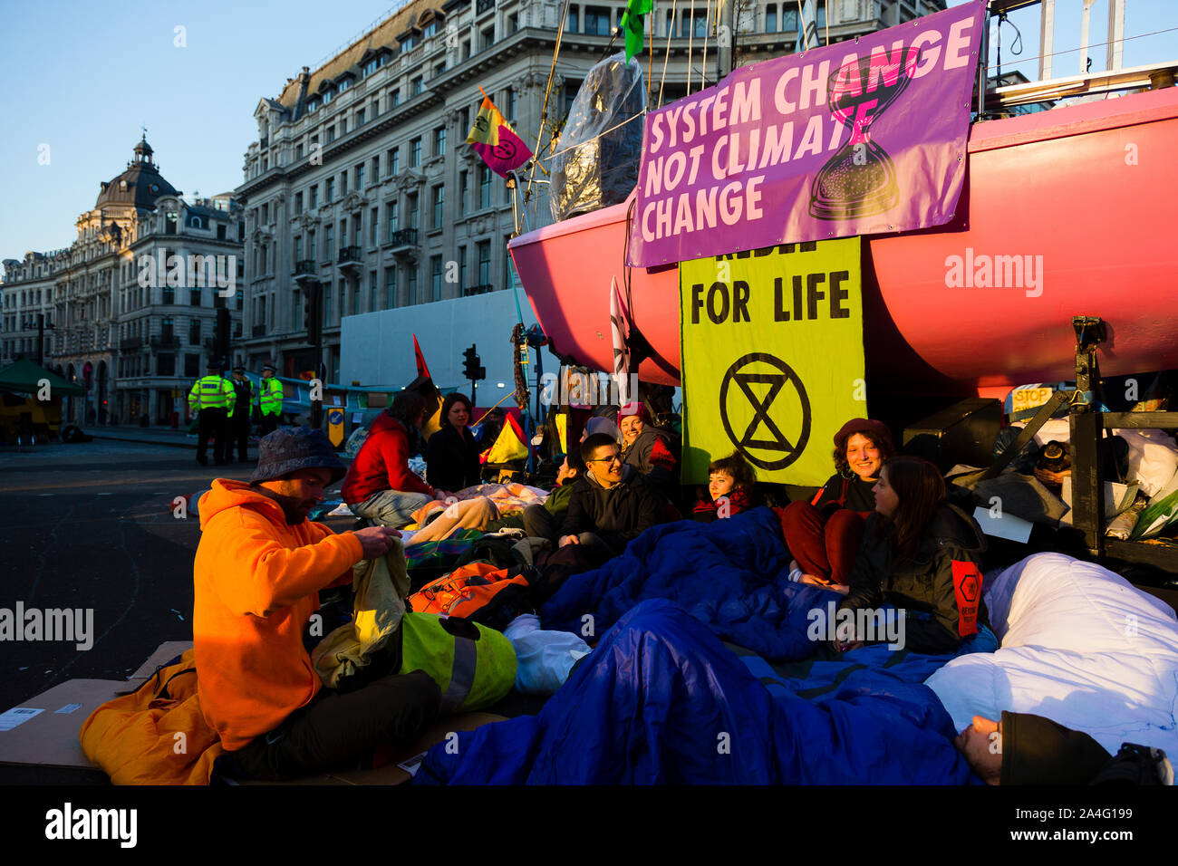 London, Großbritannien. Eine Gruppe von Aussterben Rebellion Demonstranten unter einer rosa Yacht in Oxford Circus als Demonstrant geht in die fünfte Tag. Stockfoto