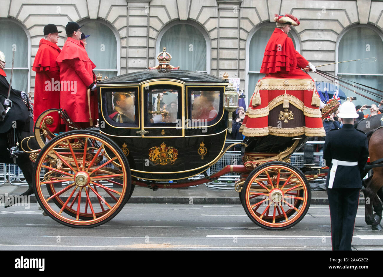 Die Krone und Schwert pass in ein Beschlagen von Pferden gezogene Trainer als Ihre Majestät Königin Elizabeth zu geht das Parlament ihre Rede als Teil des Staates öffnen, um das Gesetzgebungsprogramm der Regierung zu enthüllen. Stockfoto