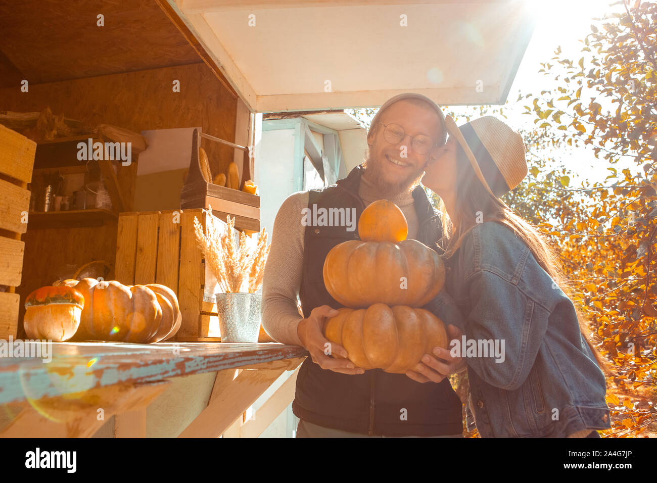 Junge erwachsene Frau und Mann küssen und kaufende frische Kürbis in Lebensmittelgeschäft Stockfoto