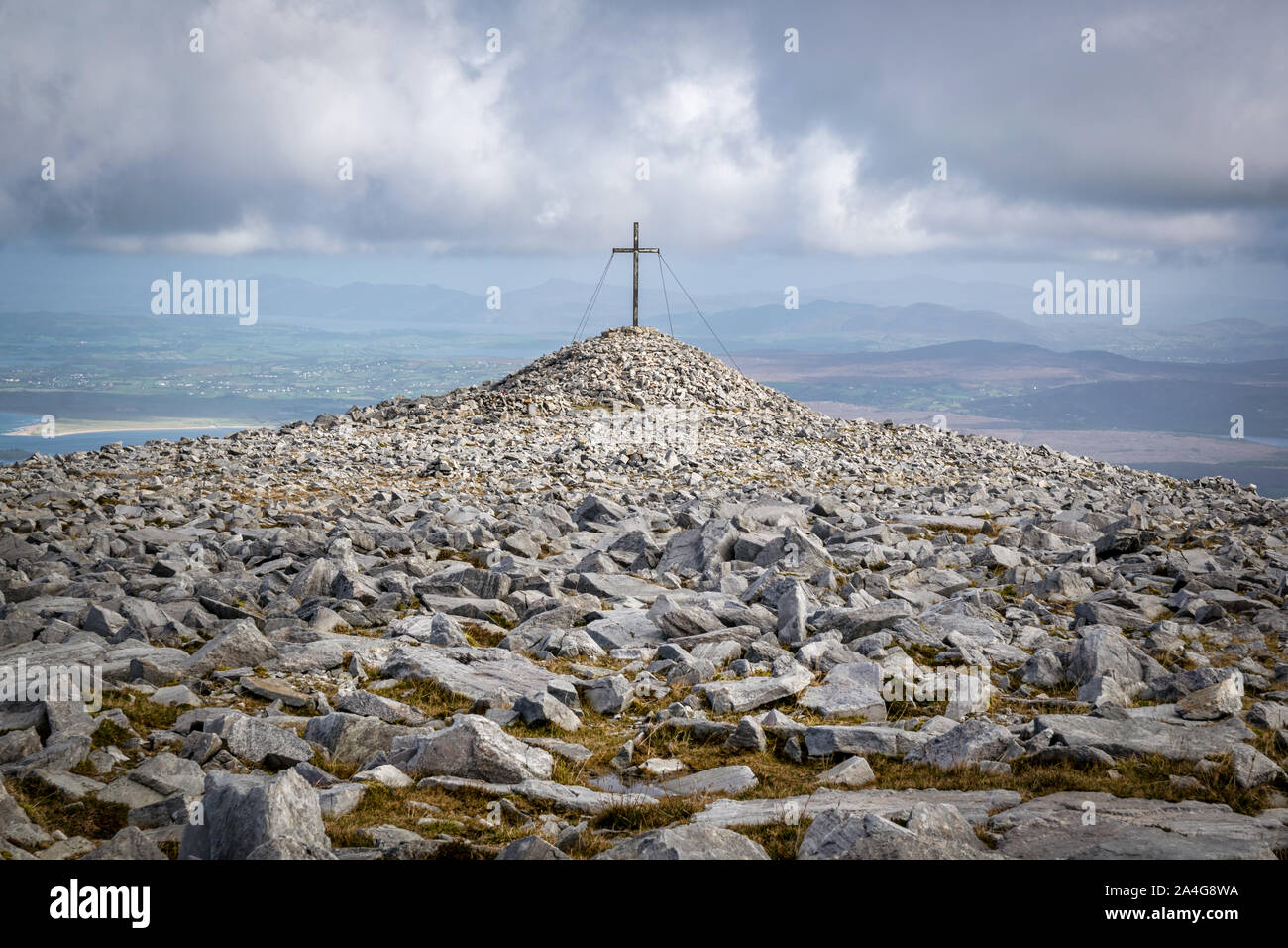 Die schroffen und felsigen flache Oberseite der Muckish Berg in Donegal Ierland. In der Ferne ist ein Kreuz ontop von einem der höchsten Punkte der Berg Stockfoto
