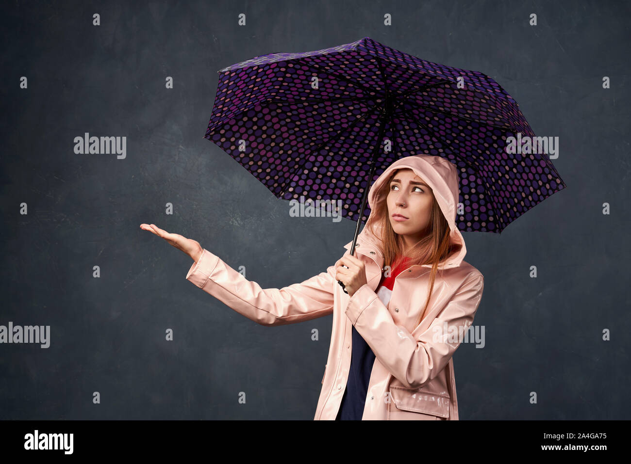 Mädchen in Regenmantel aus Regen, mit einem Regenschirm Stockfoto