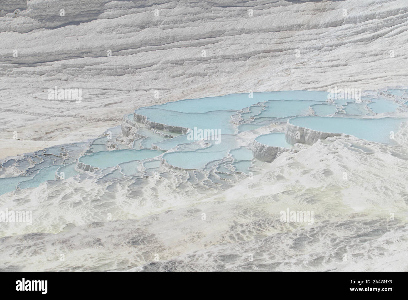 Pamukkale in der Türkei ist bekannt für seine mineral-reiche Thermalwasser nach unten fließenden weißen Travertin Terrassen. Pamukkale ist unter dem Spitznamen Baumwolle schloss. Stockfoto