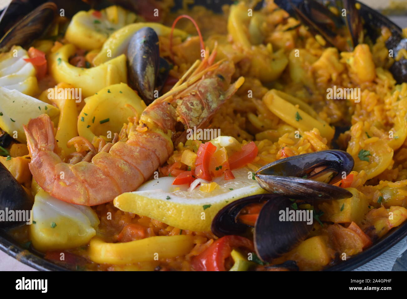 Extreme Nahaufnahme der Paella. Riesige Garnelen auf Risotto. Muscheln, Muscheln, Tintenfisch, Fisch, Krebse tragen zur authentischen spanischen Geschmack. Stockfoto