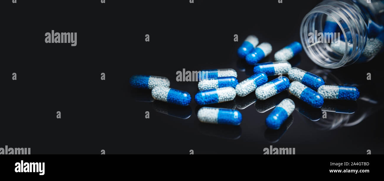 Stapel von verschüttetem Kapseln auf schwarzem Hintergrund. Apotheke Konzept Stockfoto