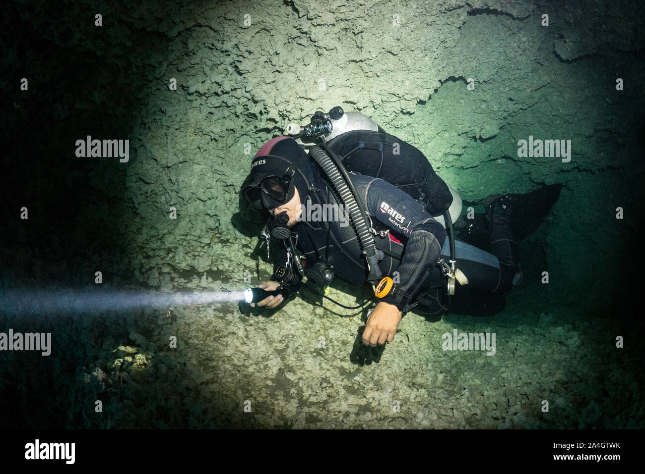 Ein Scuba Diver verlässt eine kleine Höhle Passage in Angelita cenote in Mexiko. Stockfoto