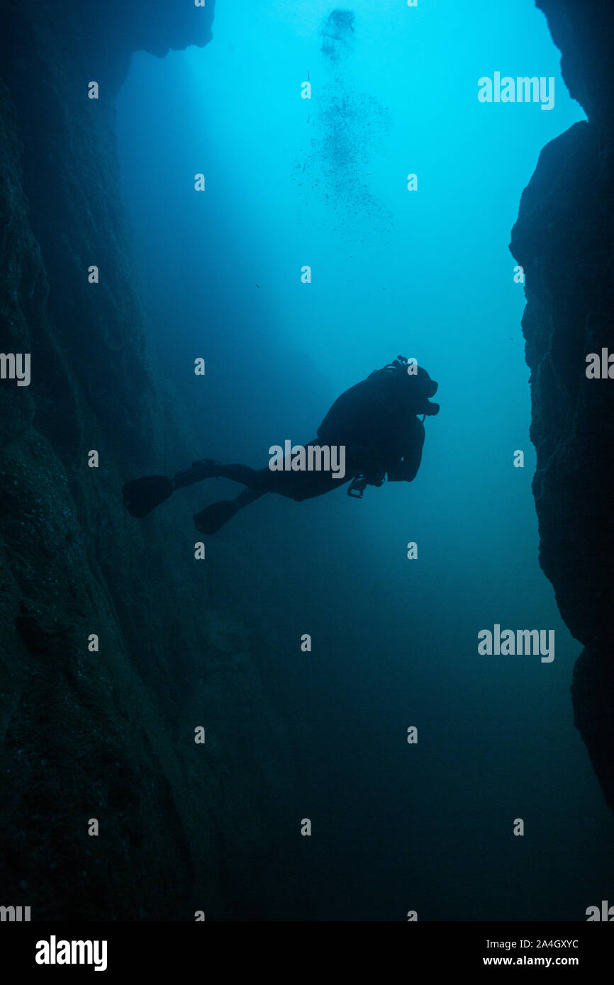 Ein Scuba Diver erstellt eine markante Silhouette von außerhalb eine Unterwasserhöhle bei Land's End im Marine Park Cabo San Lucas, Mexiko. Stockfoto