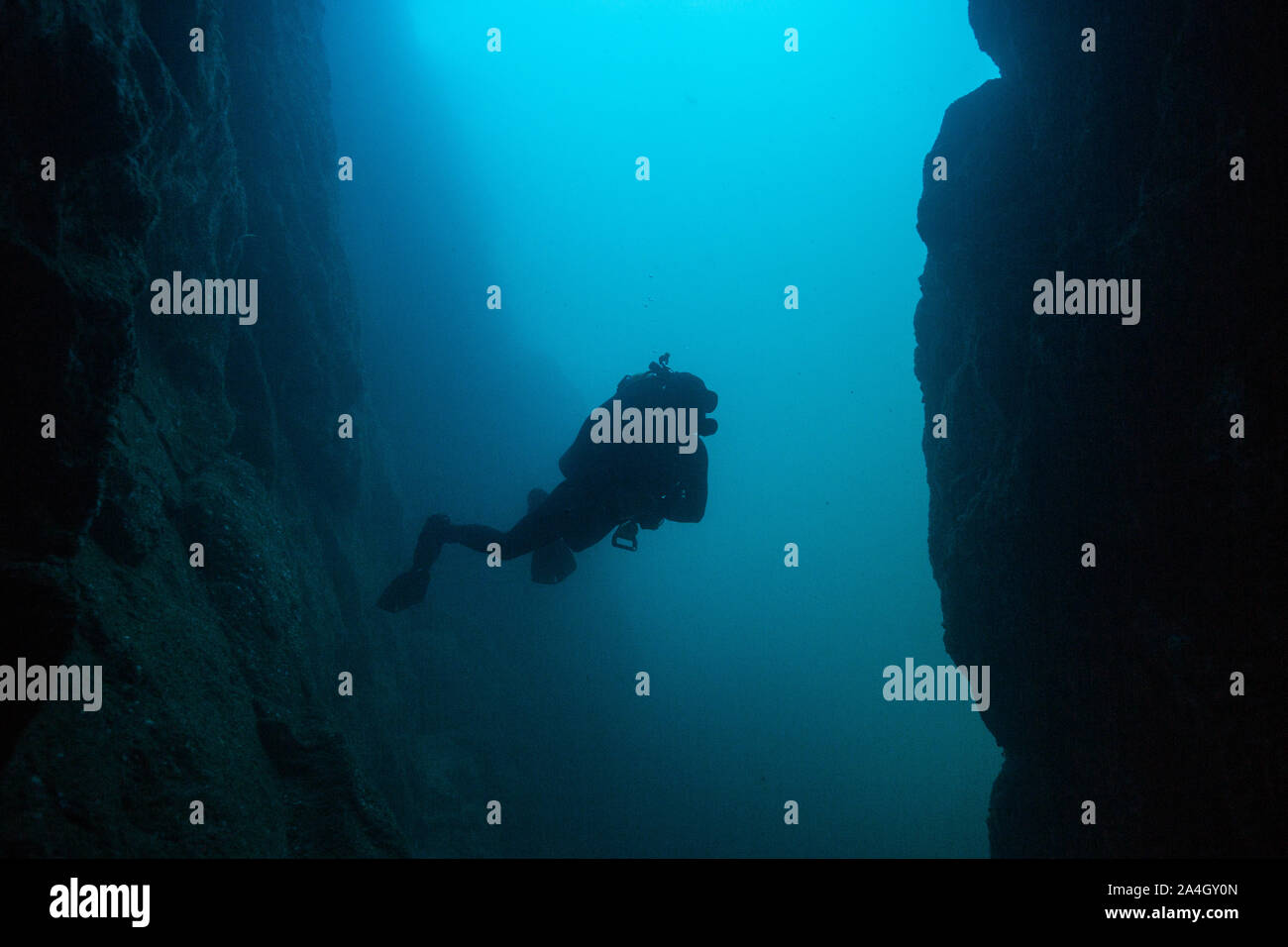 Ein Scuba Diver erstellt eine markante Silhouette von außerhalb eine Unterwasserhöhle bei Land's End im Marine Park Cabo San Lucas, Mexiko. Stockfoto