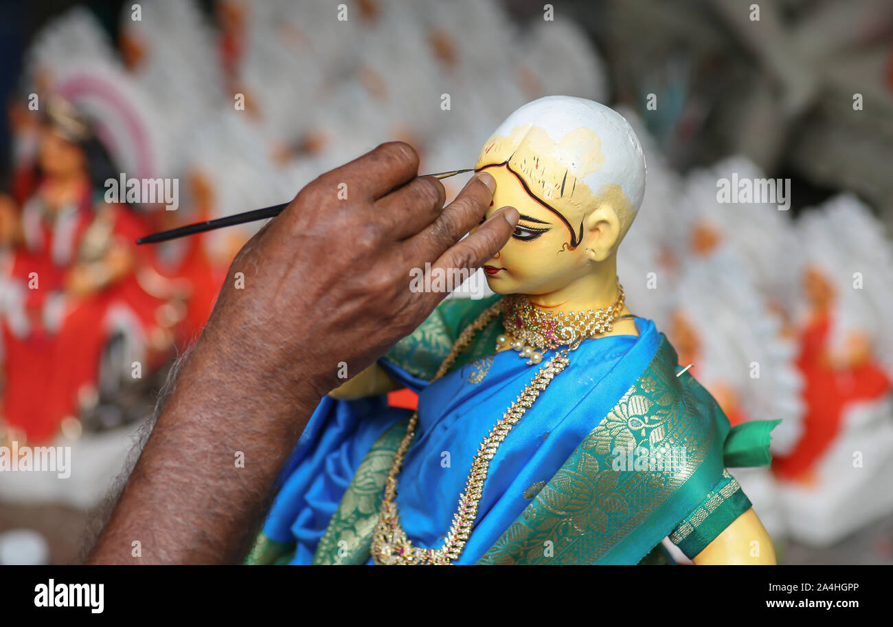 Hand des Künstlers mit Pinsel, die letzten Schliff auf das Idol der Göttin Durga im Gebiet Kumartuli in Kolkata, Indien, auftragen Stockfoto