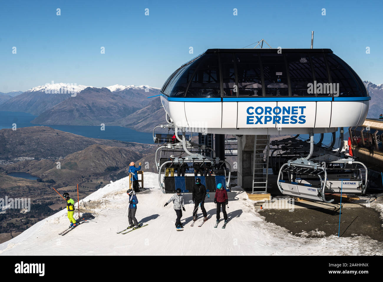 Queenstown, Neuseeland - 7. September 2019: Skifahrer und Snowboarder fahren mit dem Sessellift in der Coronet Peak Ski Resort in Neuseeland im Frühjahr mit See W Stockfoto