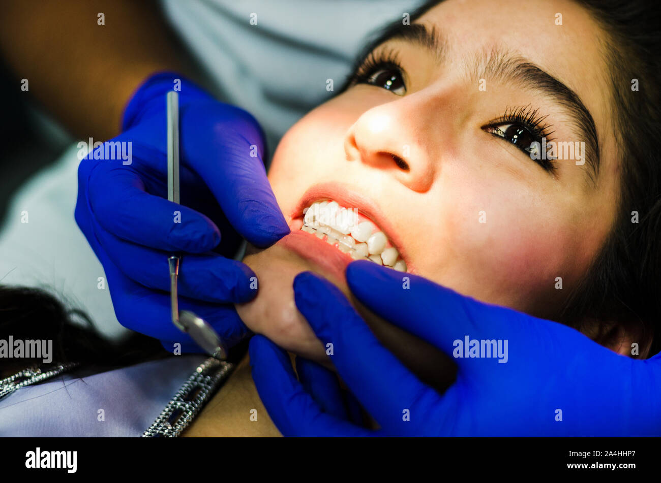 Die Frau kam zum Zahnarzt. Sie sitzt in den zahnmedizinischen Stuhl. Der Zahnarzt beugte sich über sie. Gerne Patient und Zahnarzt Konzept. Stockfoto